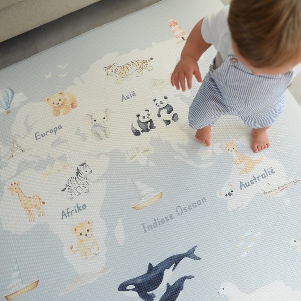 Child standing on a world map play mat