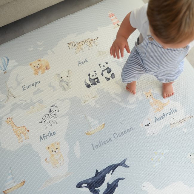 Child standing on a world map play mat