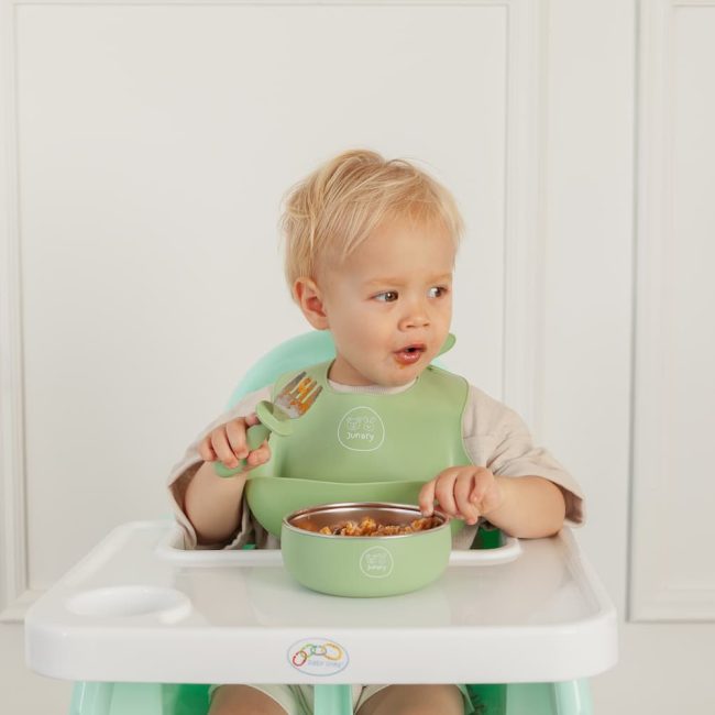 Toddler using Junary fork and spoon set designed for self-feeding and baby-led weaning