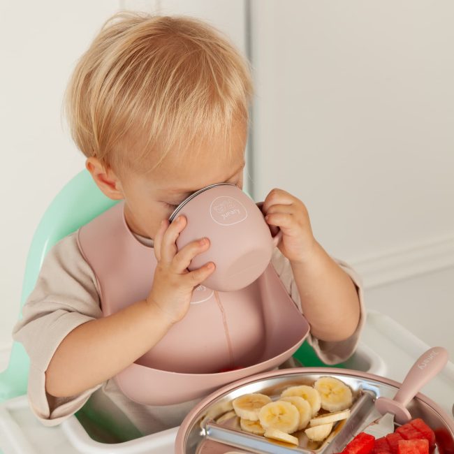 Toddler wearing a silicone bucket bib during mealtime to catch food and reduce mess